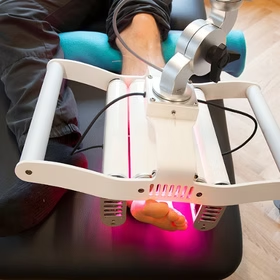 Red light laser therapy bed treating an athlete's leg for sports recovery in Dublin